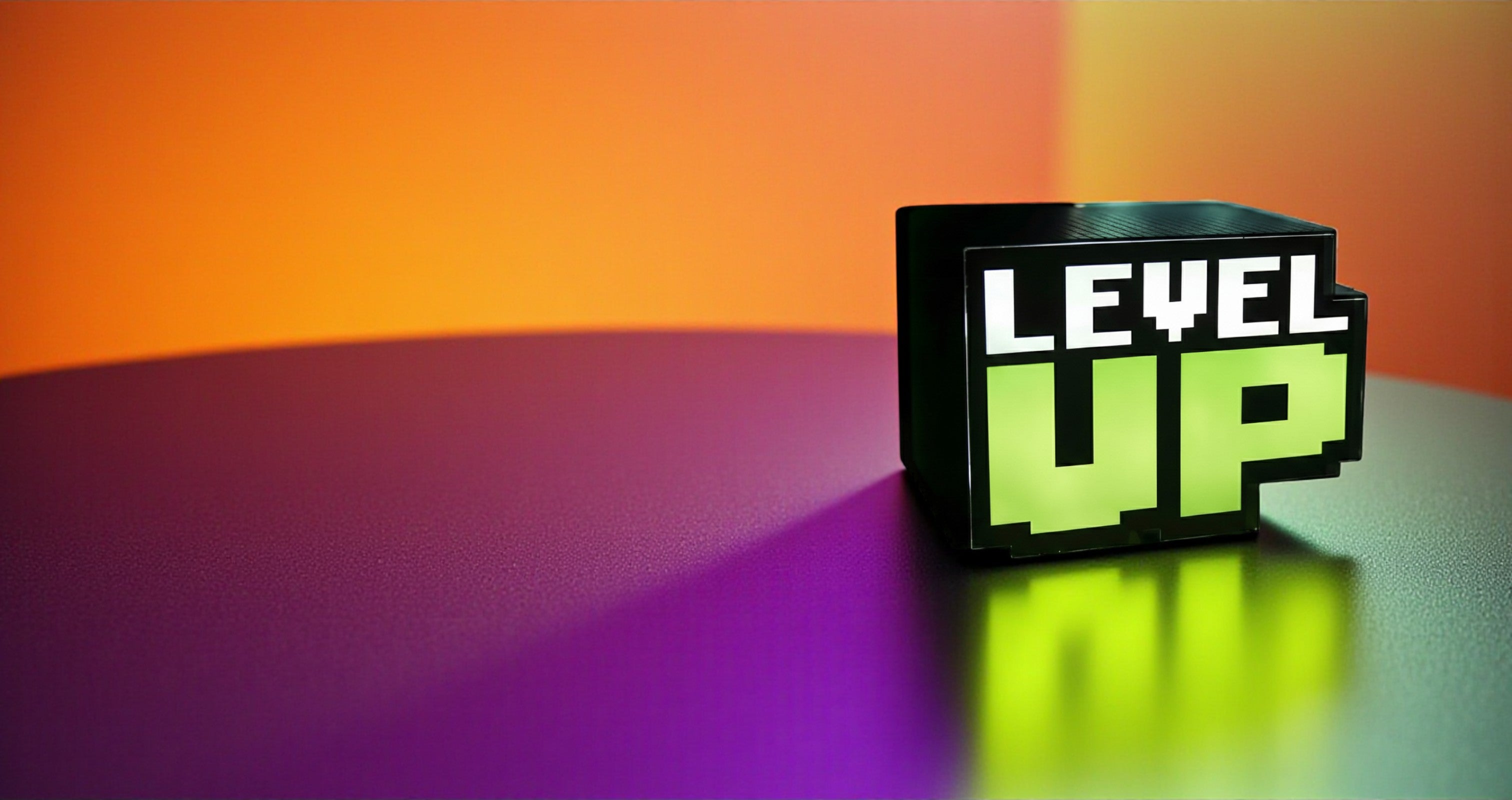 Black box with 'LEVEL UP' text on a gradient orange to purple background